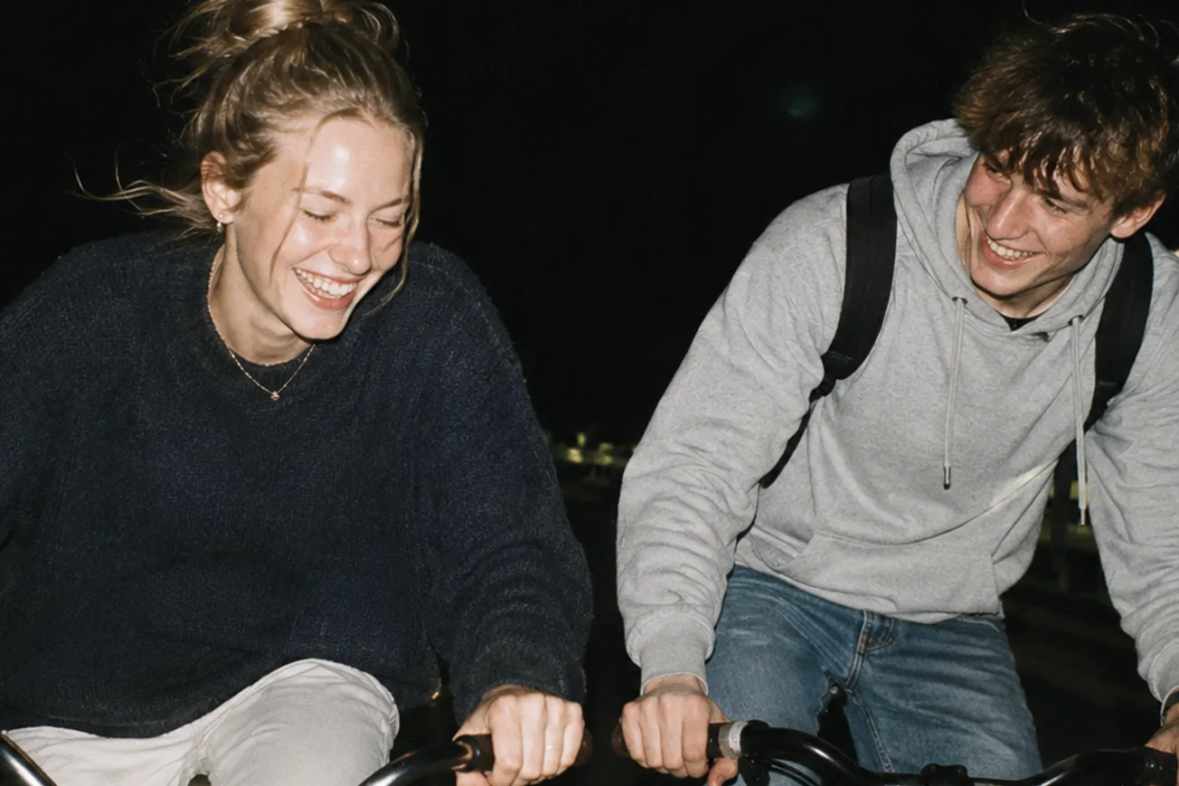 Två unga personer cyklar bredvid varandra.