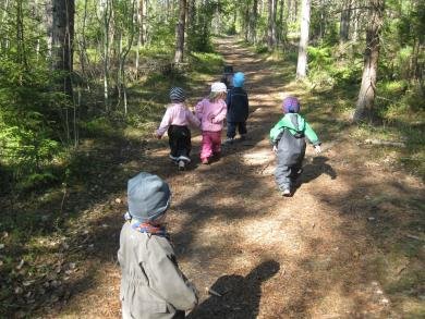 barn som leker i skogen.