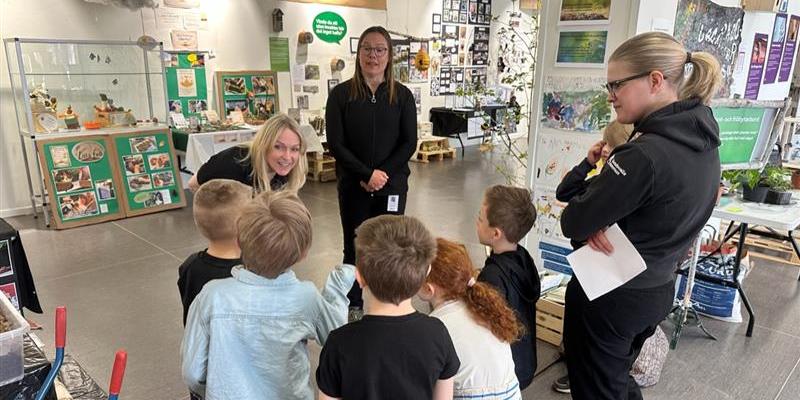 Biolog och landskapsarkitekt möter barngrupp i utställningen.