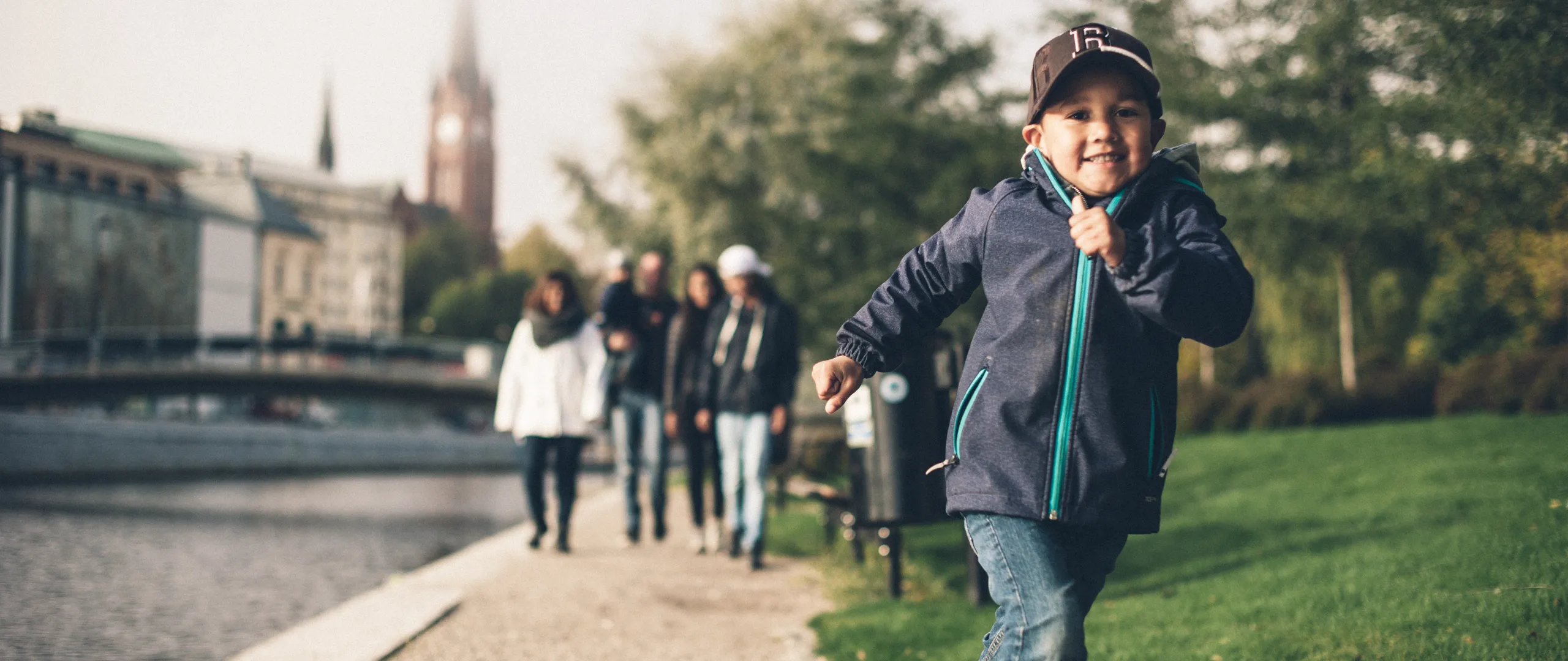 En familj promenerar längs en å. En pojke springer i förgrunden. Foto: Evelina Ytterbom