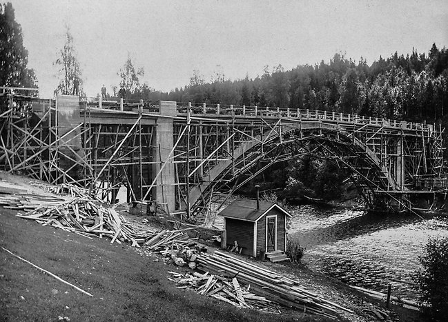 Viforsbron under uppbyggnad. I början av 1922 startade arbetet med en betongbro över Ljungan strax ovanför Viforsen. Redan i oktober samma år var bron klar. Hela brobanans längd var då 80 meter och höjden över vattenytan 15 meter. Fotograf okänd, bildkälla Sundsvalls museum.