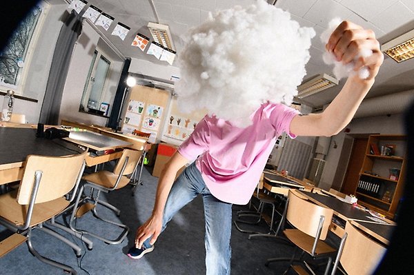 En person i ett klassrum med ett moln av vitt runt huvudet. 