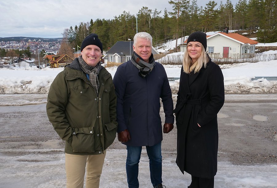 Tre personer står utomhus med utsikt över Sundsvall i bakgrunden.