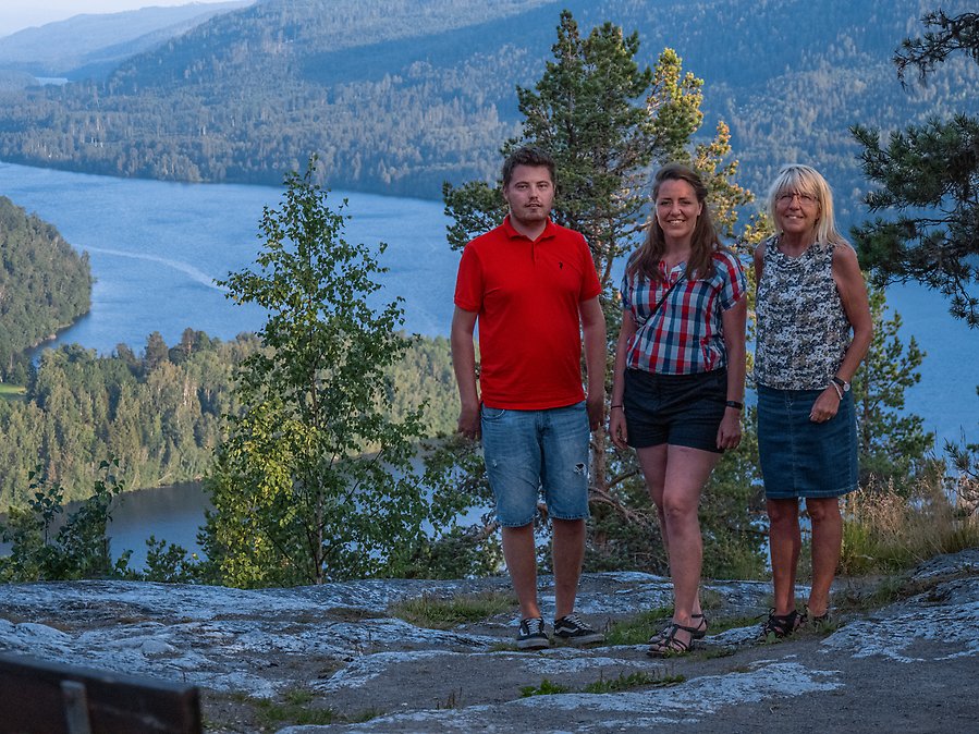 Tre personer står på Vättaberget med Indalsälven i bakgrunden.