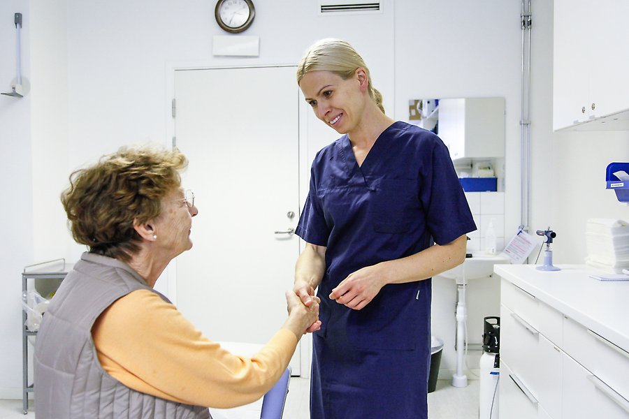 Sjuksköterska skakar hand med patient.