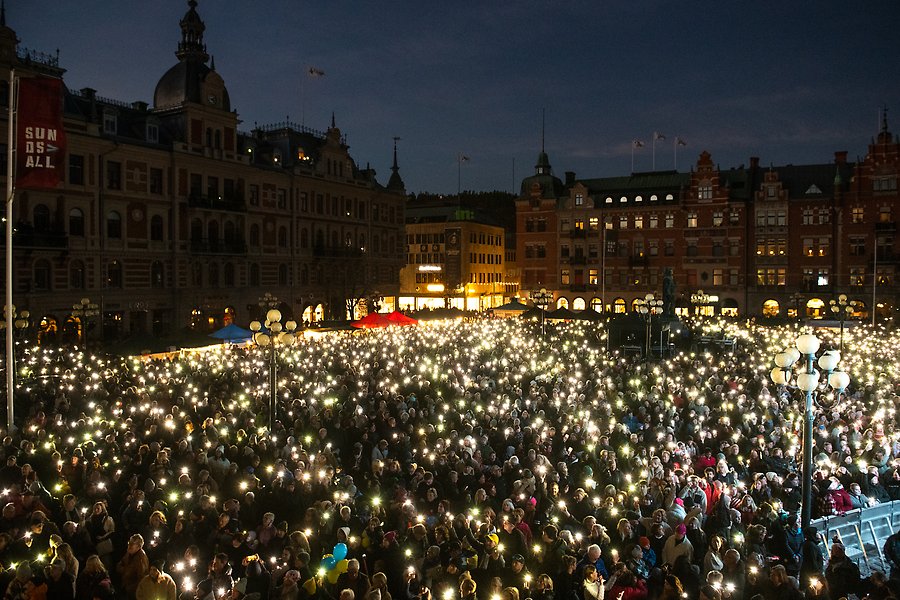 Stora torget i Sundsvall är fullt av personer som lyser med sina mobiltelefonlampor i mörka novemberkvällen.