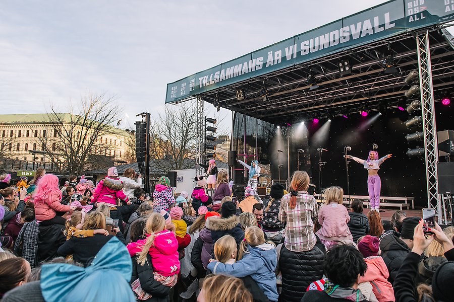 Popgruppen Dolly Style står på uppträder på scenen under Lyslördag 2022. I publiken finns massor av barn.