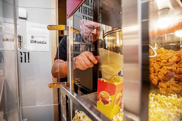 Mats Persson plockar popcorn ur popcornmaskin.