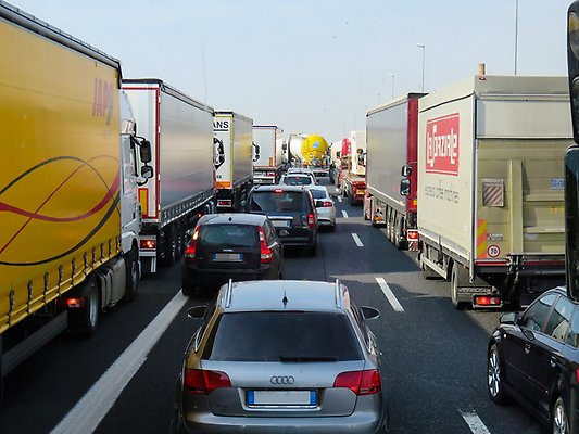 Bilar och lastbilar i kö på motorväg