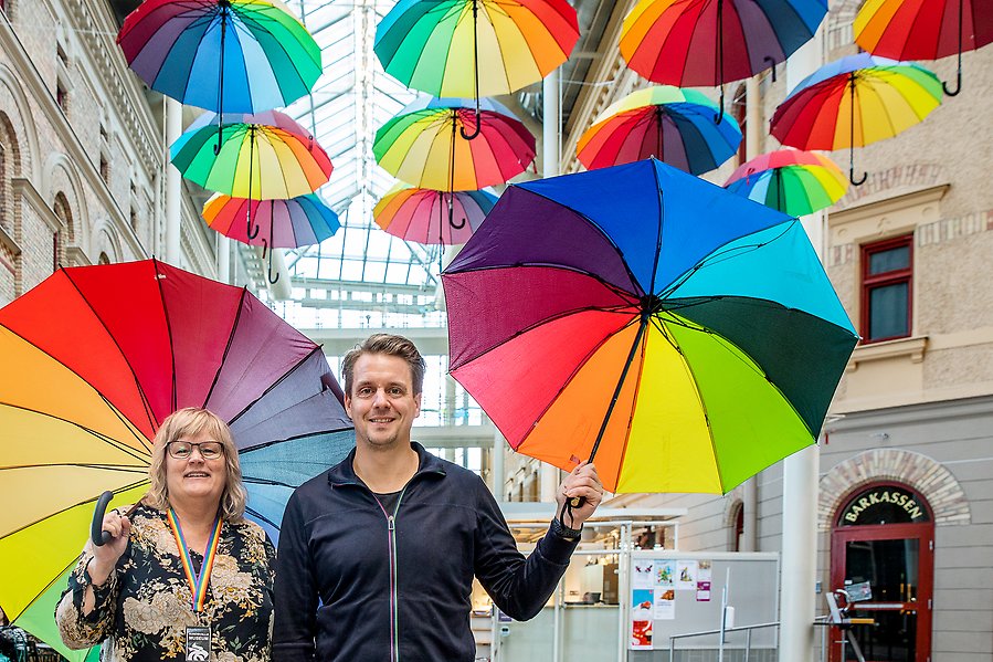 En man och en kvinna håller i ett pride-paraply