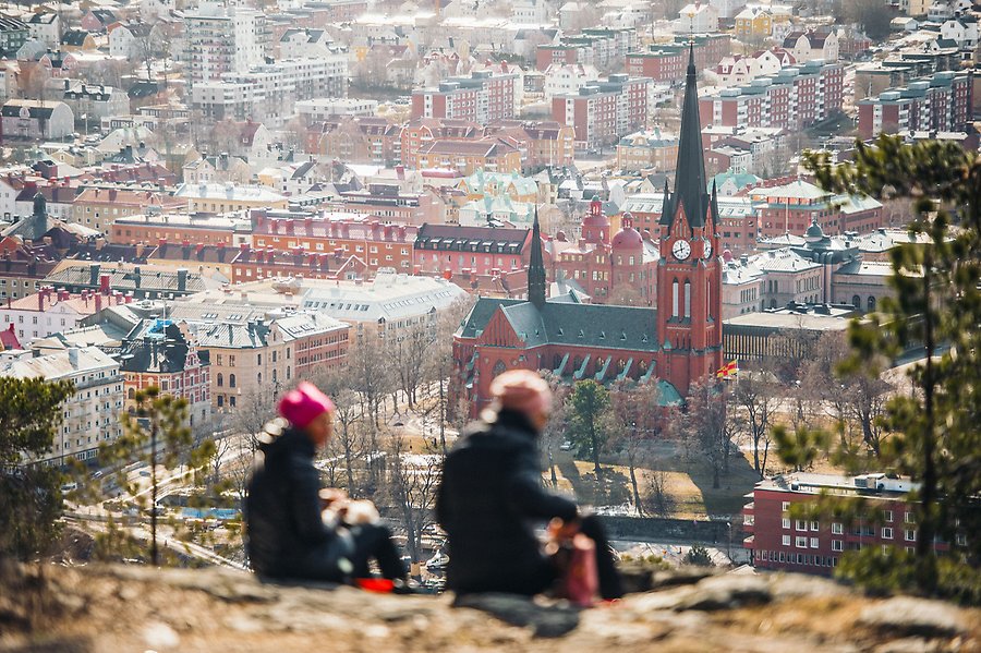Två personer som fikar på Norra Berget med utsikt över Sundsvall.