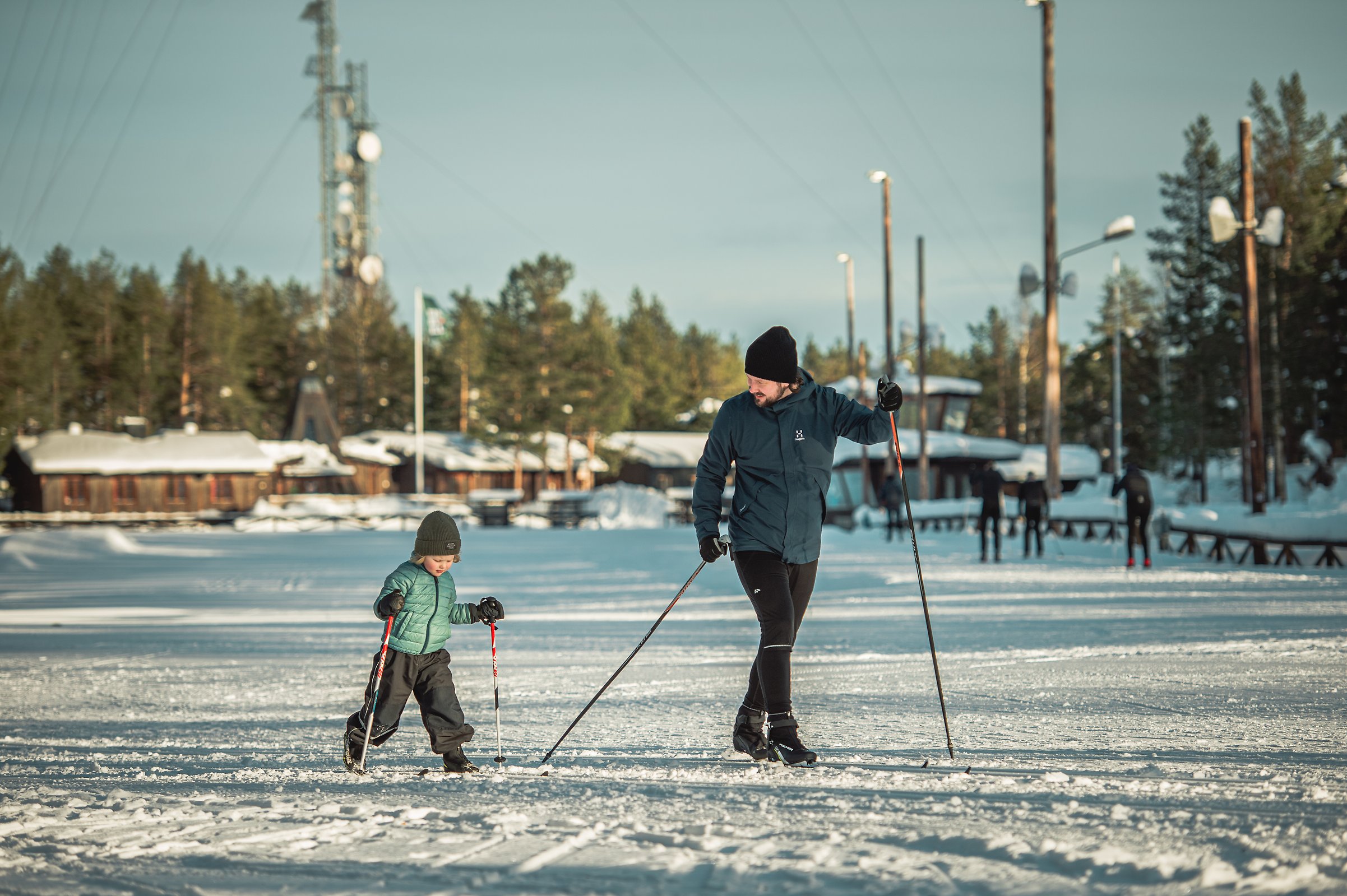 Ett barn och en vuxen åker längdskidor